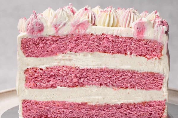 A slice of pink cake on a silver plate.